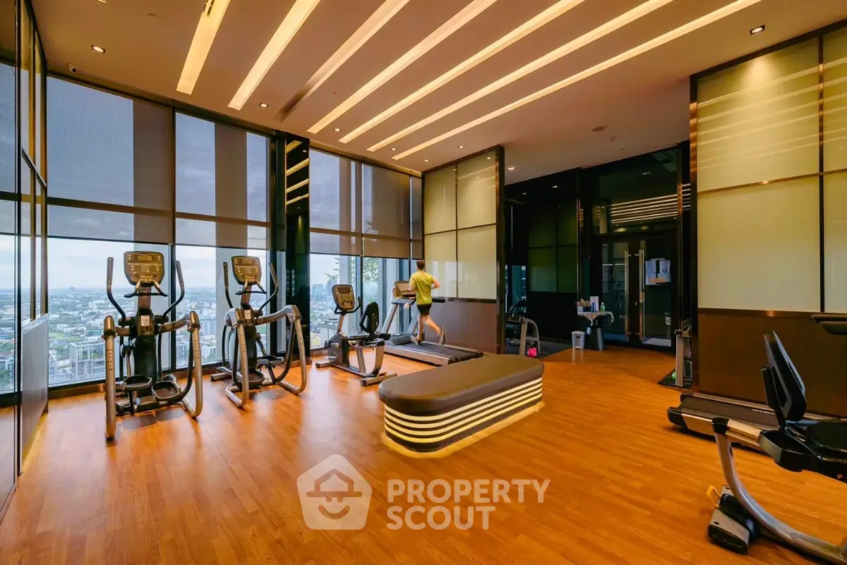 Luxurious high-rise gym with panoramic city views and modern fitness equipment.