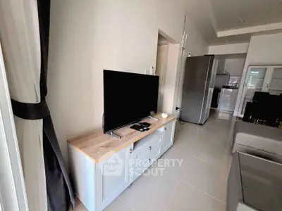 Modern living room with sleek TV setup and open kitchen layout