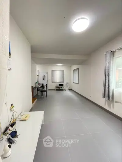 Spacious and minimalist living room with modern decor and ample natural light.