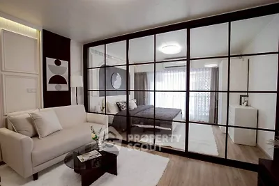 Modern studio apartment with glass partition, cozy living area, and stylish bedroom.