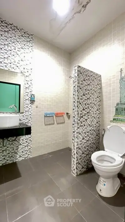 Modern bathroom with mosaic tiles and unique wall art