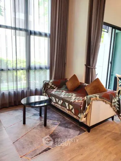 Stylish living room with modern sofa and floor-to-ceiling windows for natural light.