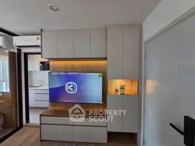 Modern living room with sleek cabinetry and wall-mounted TV in a stylish apartment