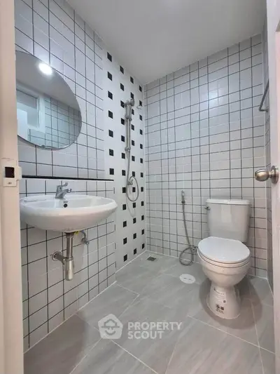 Modern bathroom with sleek tiles and contemporary fixtures in a stylish real estate property.