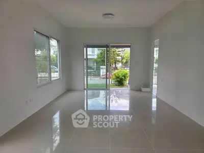 Spacious living room with large windows and garden view, perfect for natural light lovers.