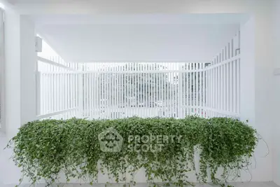 Modern balcony with lush greenery and sleek white railing design