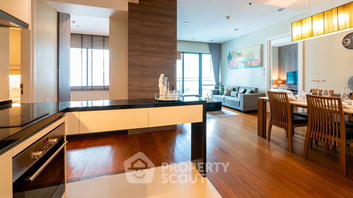 Spacious open-plan living and dining area with modern kitchen in luxury apartment.