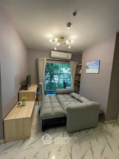 Cozy living room with modern sofa, TV, and balcony view in stylish apartment.