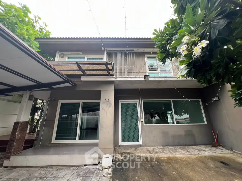Charming two-story home with lush greenery and spacious balcony