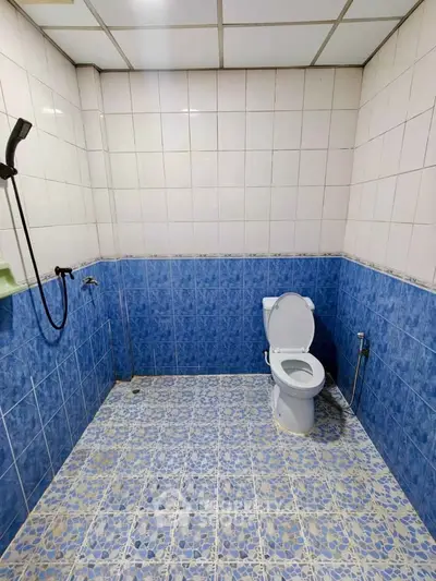 Spacious bathroom with blue and white tile design, featuring modern fixtures.