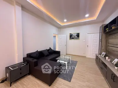 Modern living room with sleek black sofa and elegant ceiling lighting