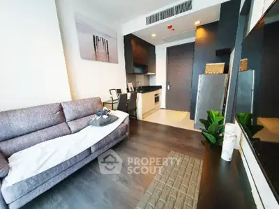 Modern living room with sleek kitchen, cozy sofa, and stylish decor in a contemporary apartment.
