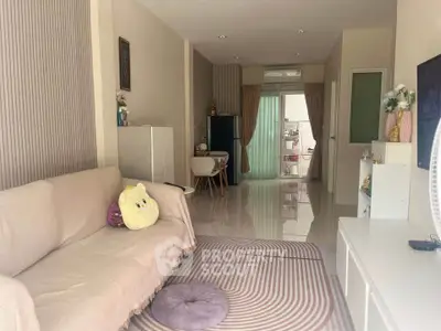 Cozy living room with modern decor and open layout, featuring a comfortable sofa and stylish rug.