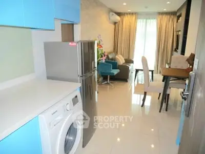 Modern open-plan kitchen and living room with sleek appliances and stylish decor.