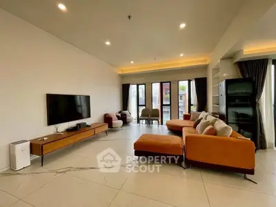 Spacious modern living room with stylish furniture and large windows offering natural light.