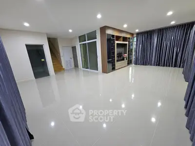 Spacious modern living room with glossy tile flooring and elegant curtains