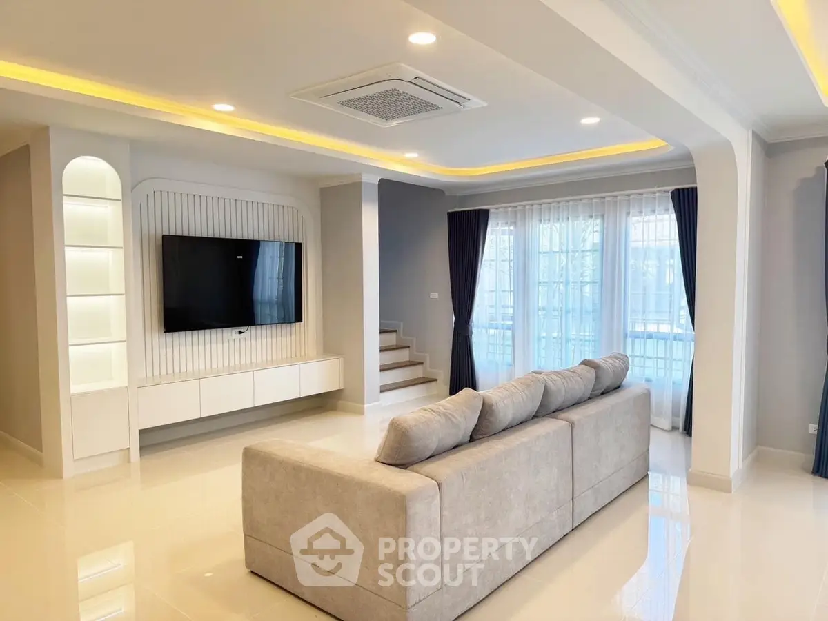 Spacious modern living room with elegant lighting and large sofa, perfect for relaxation and entertainment.