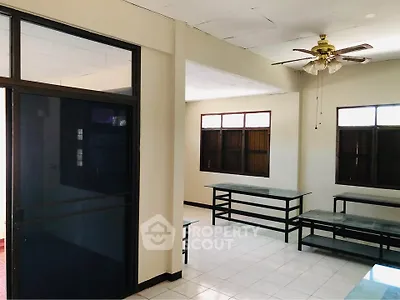 Spacious interior with large windows and ceiling fan, ideal for versatile use.