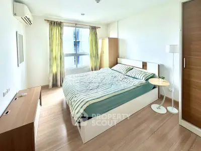 Spacious and bright bedroom with modern furnishings and large window view.
