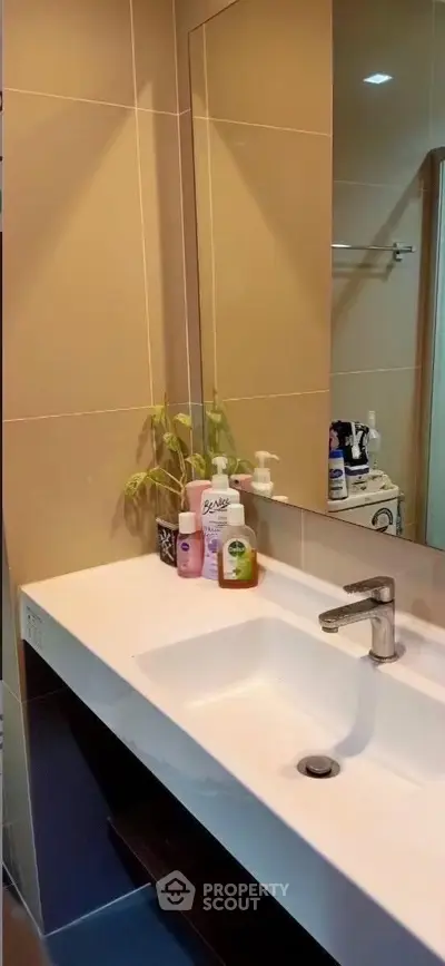 Modern bathroom with sleek sink and mirror, featuring stylish fixtures and elegant design.