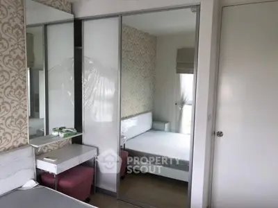 Modern bedroom with mirrored wardrobe and stylish wallpaper accent wall.