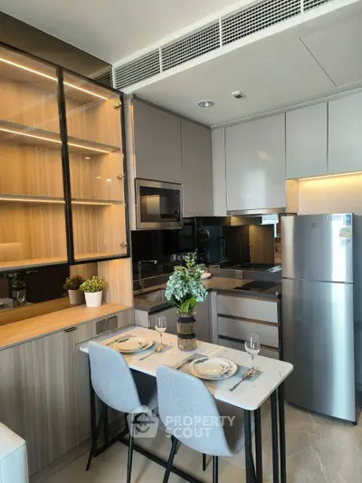 Modern kitchen with sleek cabinetry, stainless steel appliances, and cozy dining area for two.