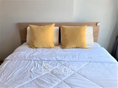 Cozy bedroom with stylish bedding and modern headboard, perfect for relaxation.