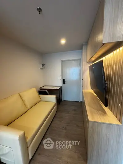 Modern living room with sleek wooden cabinetry and cozy beige sofa in a stylish apartment.