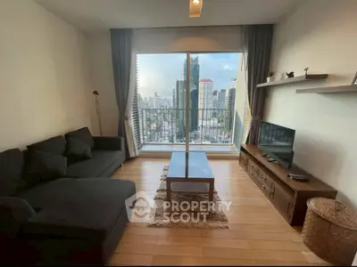 Modern living room with city view, cozy sofa, and sleek TV setup.
