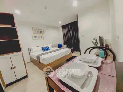Modern studio apartment with cozy bedroom and dining area, featuring stylish decor and ample storage.