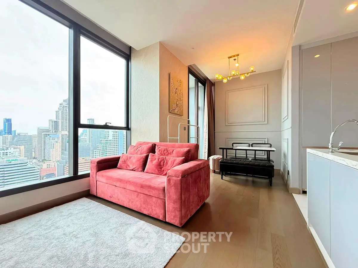 Modern living room with city view, featuring a stylish red sofa and elegant lighting.
