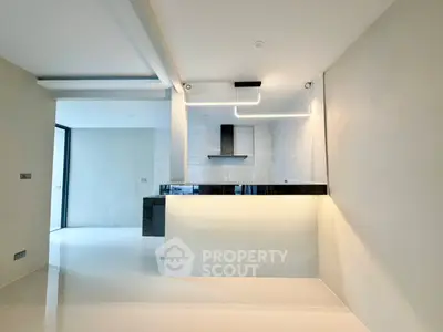 Modern kitchen with sleek design and open layout, featuring stylish lighting and high-end finishes.