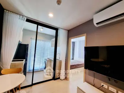 Modern apartment interior with open layout, featuring a cozy living area, dining space, and a glimpse of the bedroom.
