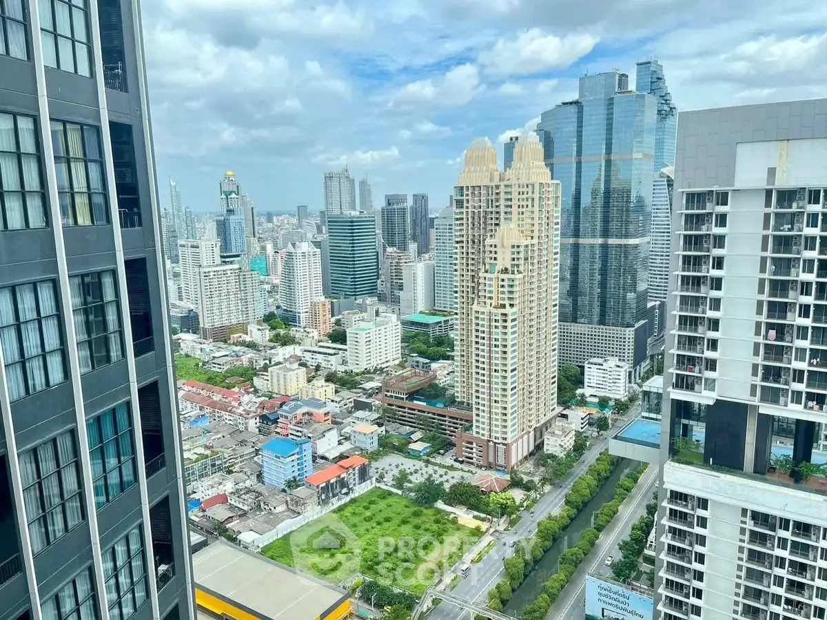 Stunning cityscape view from a high-rise building showcasing urban skyline and lush greenery.