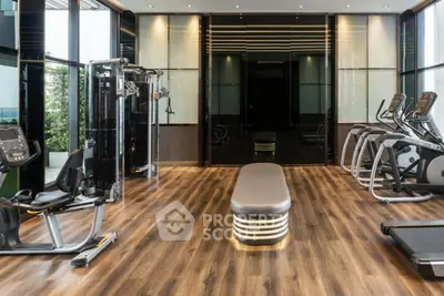 Luxurious modern gym with state-of-the-art equipment and sleek wooden flooring in a high-end residential building.