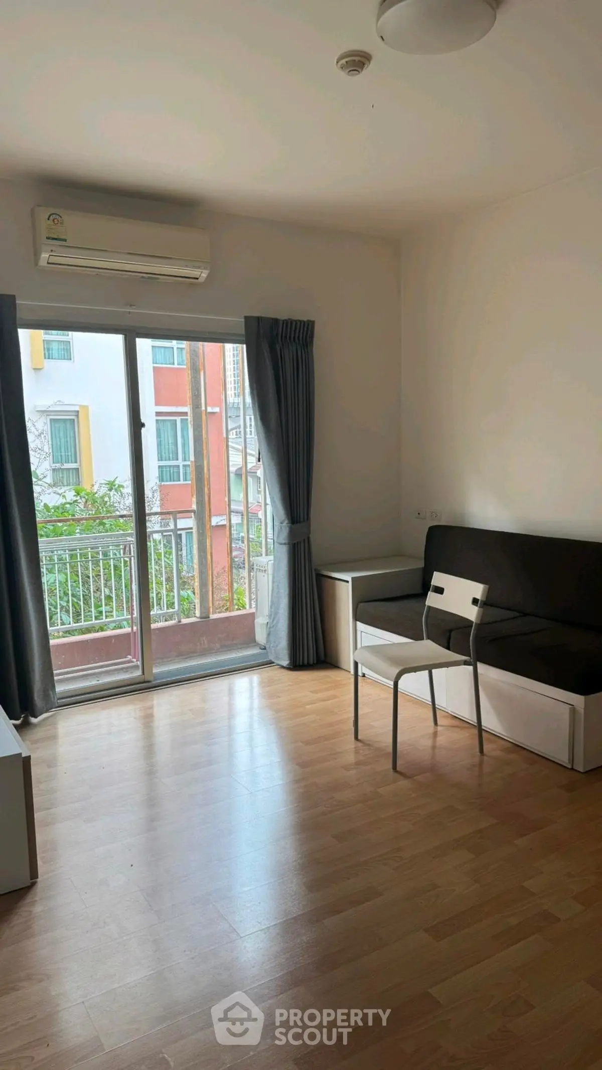 Bright living room with wooden flooring and balcony access in modern apartment.