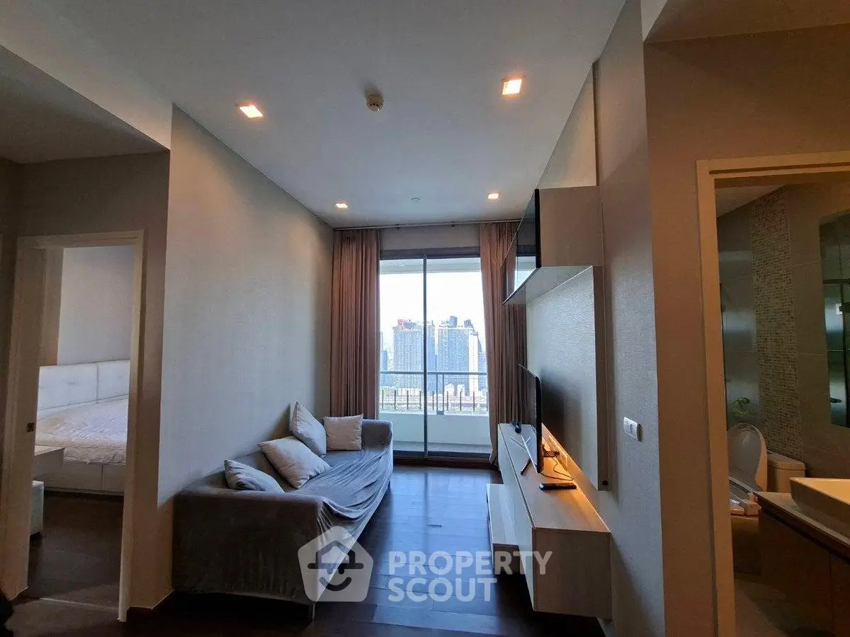 Modern living room with city view, cozy sofa, and sleek entertainment unit in a stylish apartment.