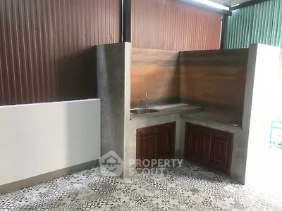 Charming outdoor kitchen with rustic design and patterned tile flooring.
