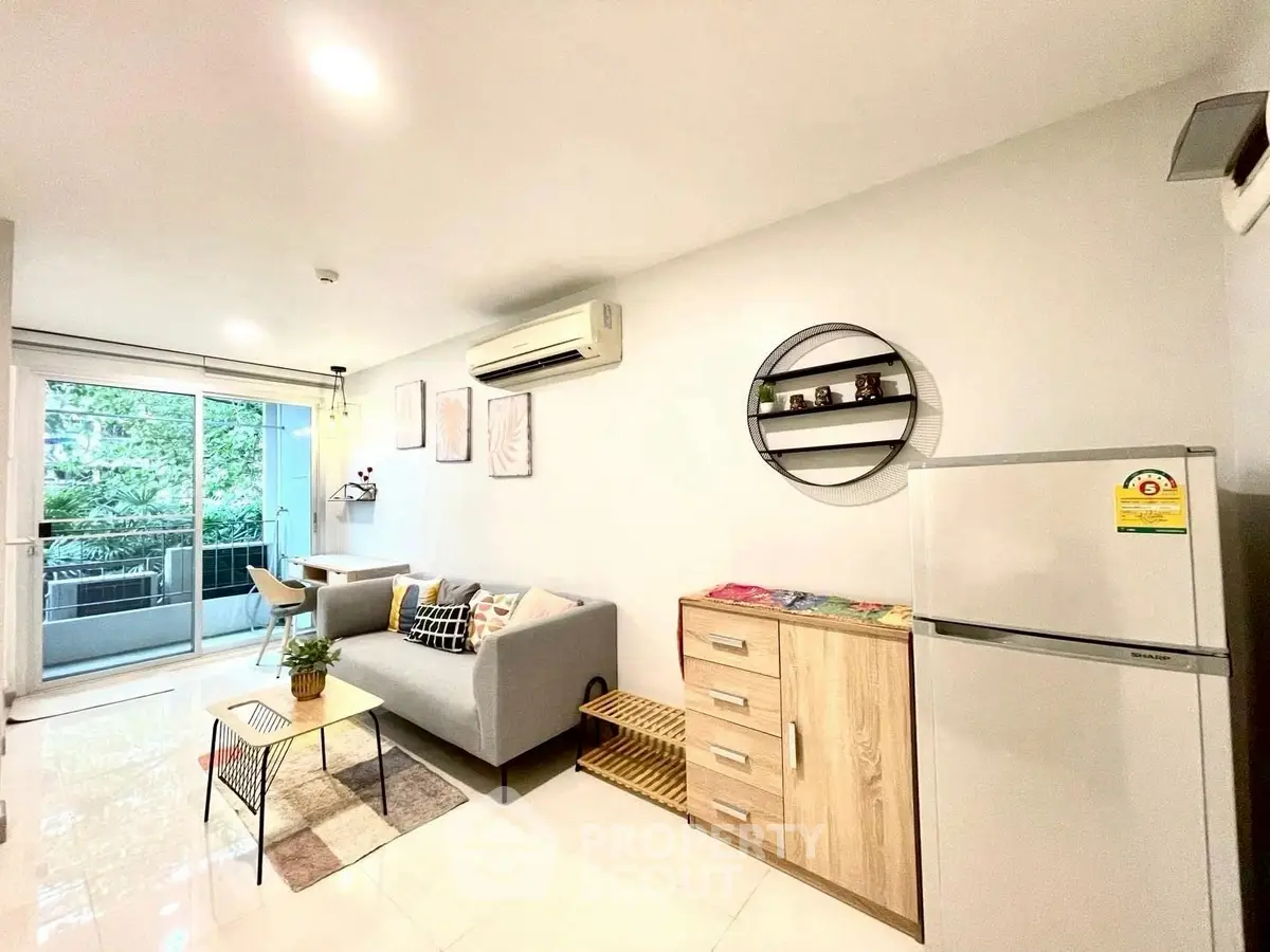 Modern living room with balcony, stylish decor, and natural light