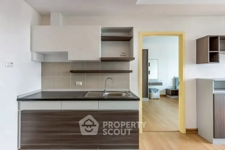 Modern kitchen with sleek cabinetry and open layout adjacent to bedroom