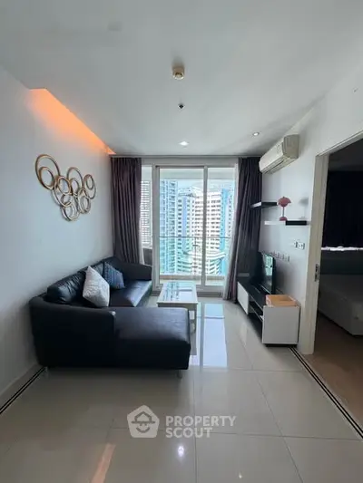 Modern living room with city view, sleek furniture, and stylish decor in a high-rise apartment.