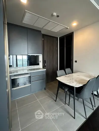 Modern kitchen with sleek cabinetry and dining area in stylish apartment