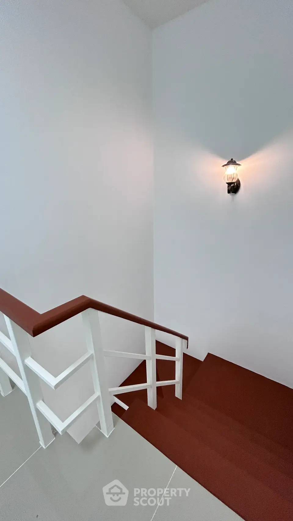 Modern staircase with sleek design and wall-mounted light fixture in a contemporary home.