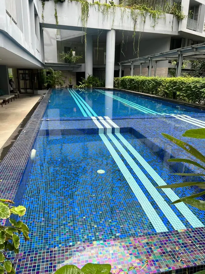 Luxurious residential pool with modern design and lush greenery, perfect for relaxation and leisure.