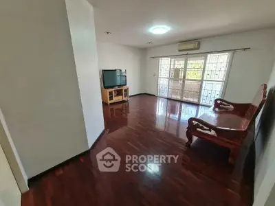 Spacious living room with wooden floors and natural light