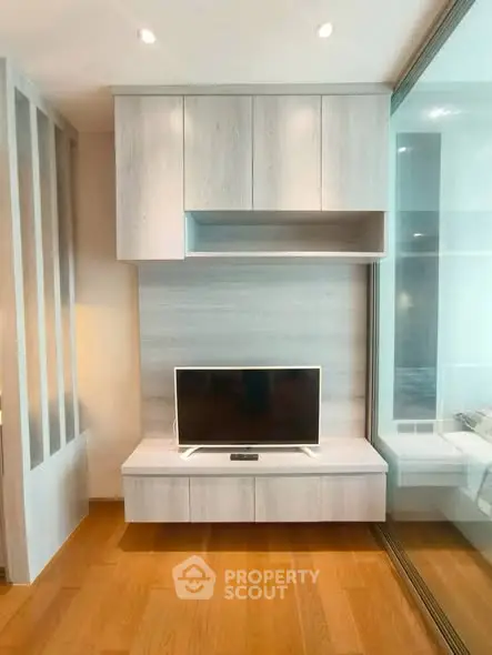 Modern living room with sleek TV unit and wooden flooring