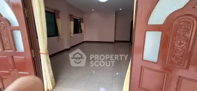 Spacious empty room with tiled floor and wooden doors, ideal for customization.