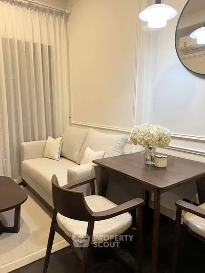 Cozy living room with elegant decor, featuring a plush sofa, stylish chairs, and ambient lighting.