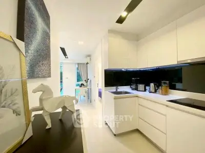 Modern kitchen with sleek white cabinets and stylish decor in a contemporary apartment.