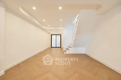 Spacious modern living room with elegant staircase and stylish lighting